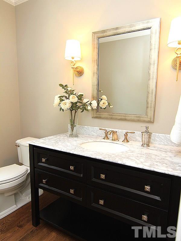 1304 Duplin Road Raleigh, NC 27607 - Photo 13 of 25 a bathroom with a granite countertop sink a toilet and a mirror
