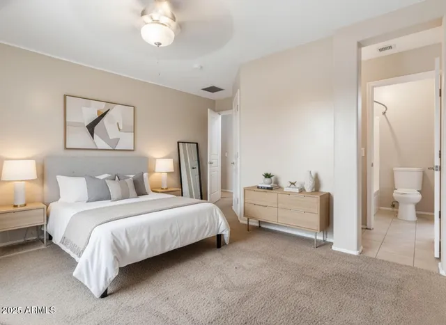 a spacious bedroom with a bed and a chandelier