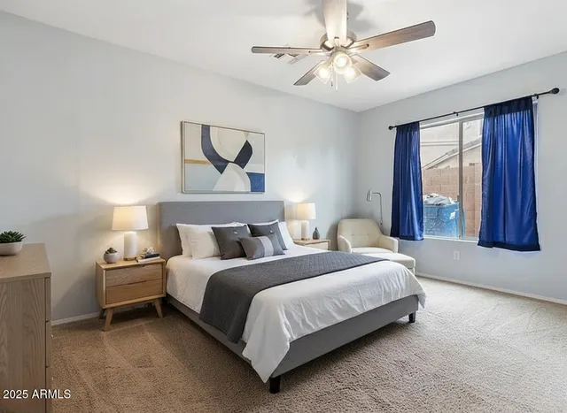 a bedroom with a bed ceiling fan and window