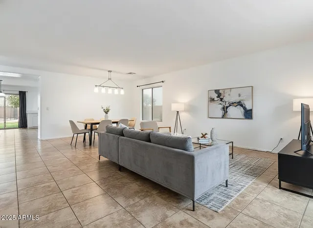 a living room with furniture and a dining table with kitchen view