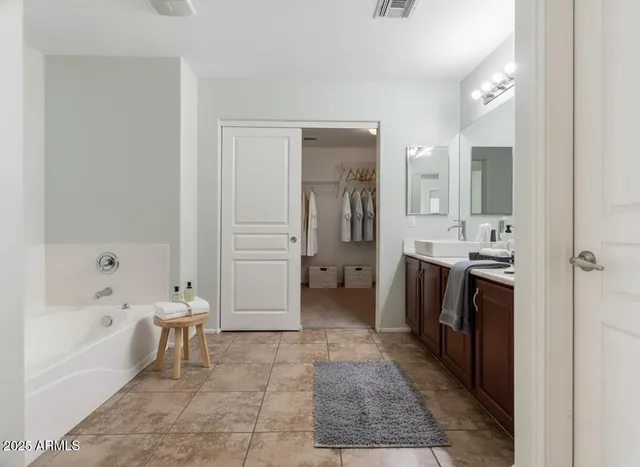 a bathroom with a tub a sink a mirror and a shower