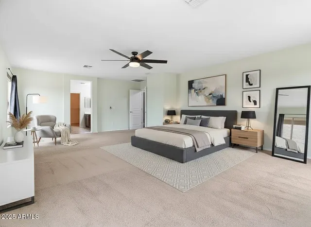 a spacious bedroom with a bed a mirror and a desk