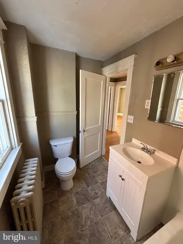 a bathroom with a sink a toilet a mirror and shower