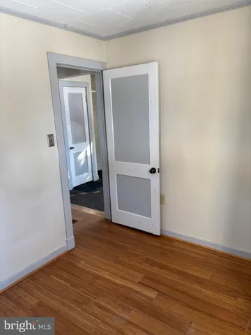 an empty room with wooden floor and a window