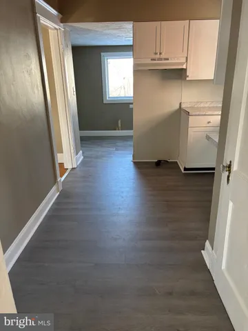 a view of a kitchen with wooden floor and cabinets