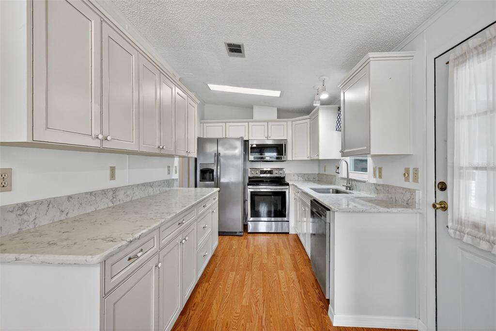 3324 Myakka River Road Tavares, FL 32778 - Photo 13 of 35 a kitchen with stainless steel appliances granite countertop a stove a sink and a refrigerator