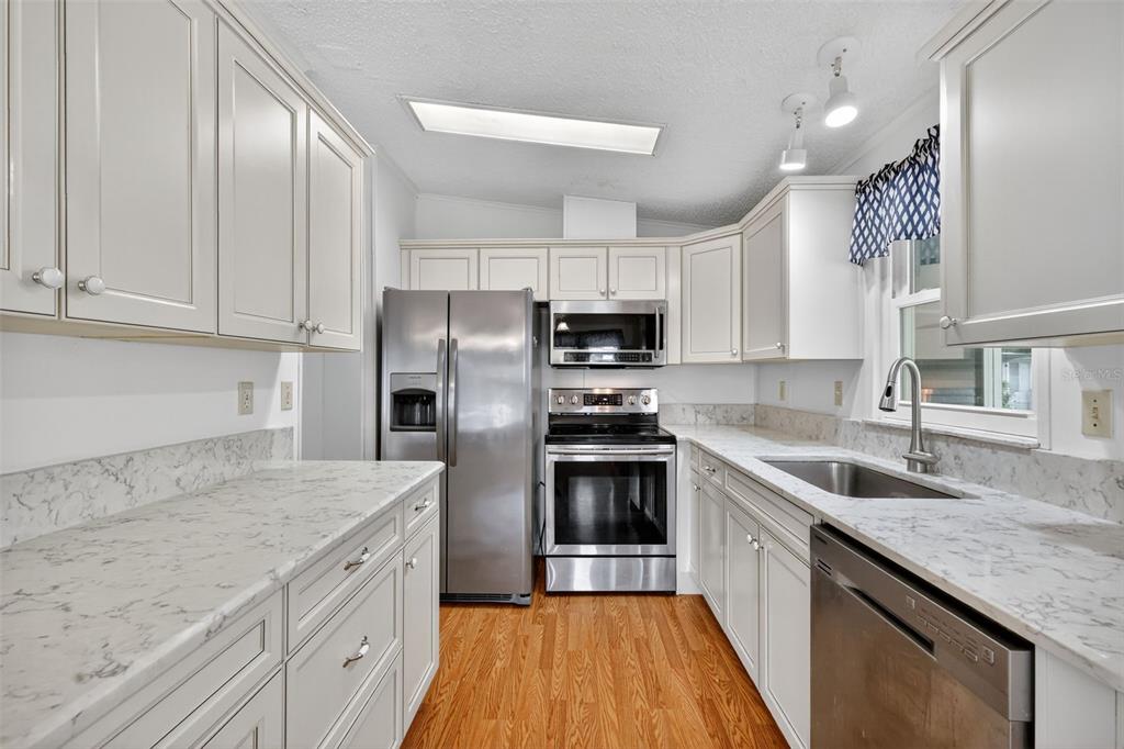 3324 Myakka River Road Tavares, FL 32778 - Photo 14 of 35 a kitchen with granite countertop a sink a counter space stainless steel appliances and cabinets