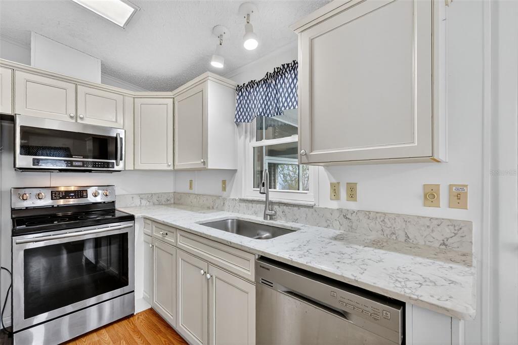 3324 Myakka River Road Tavares, FL 32778 - Photo 16 of 35 a kitchen with granite countertop a sink stainless steel appliances and cabinets