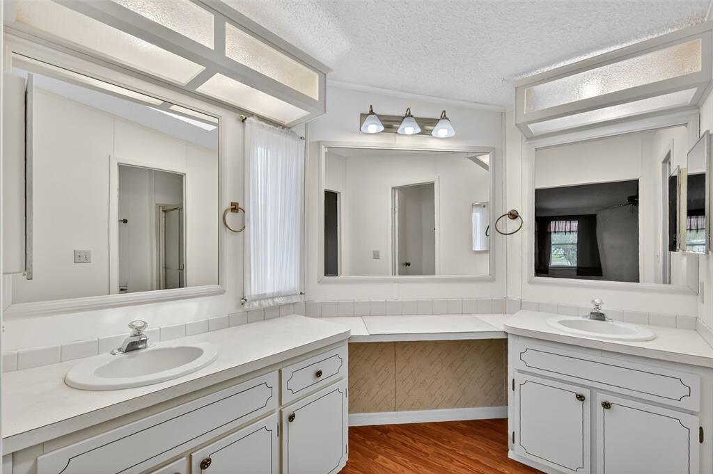 3324 Myakka River Road Tavares, FL 32778 - Photo 18 of 35 a bathroom with a sink double vanity granite and a mirror