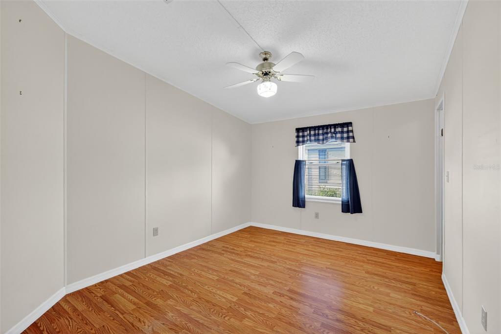 3324 Myakka River Road Tavares, FL 32778 - Photo 21 of 35 a view of an empty room with wooden floor and a window