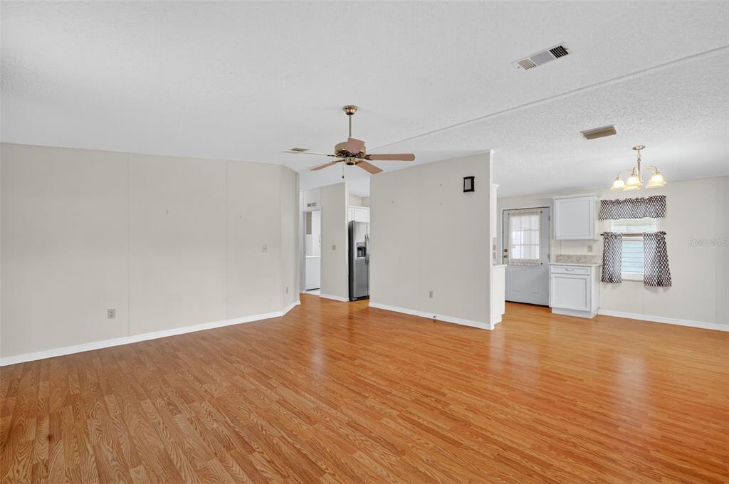 3324 Myakka River Road Tavares, FL 32778 - Photo 8 of 35 an empty room with wooden floor ceiling fan and windows
