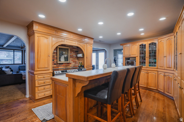 980 Cactus Circle St. George, UT 84790 - Photo 7 of 77 Kitchen with arched walkways, a kitchen island with sink, a breakfast bar, recessed lighting, and light countertops