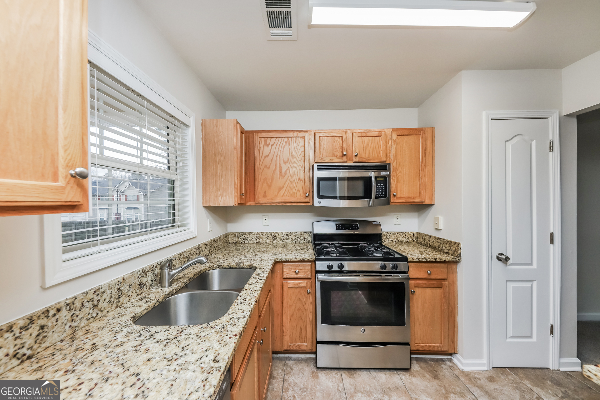102 Rocky Branch Way Villa Rica, GA 30180 - Photo 15 of 16 a kitchen with stainless steel appliances granite countertop a sink stove and microwave