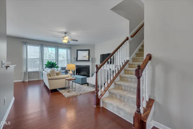 a living room with furniture and a dining table with wooden floor