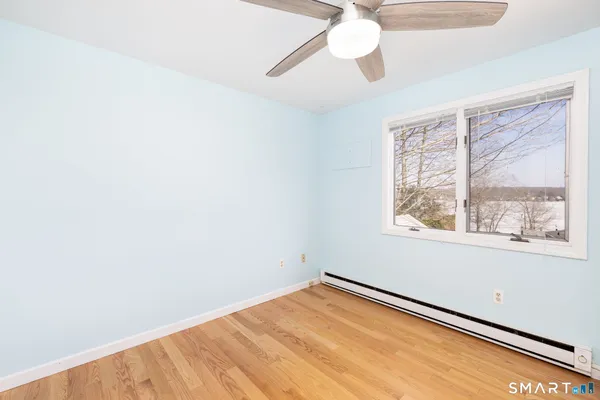 an empty room with a window and a ceiling fan