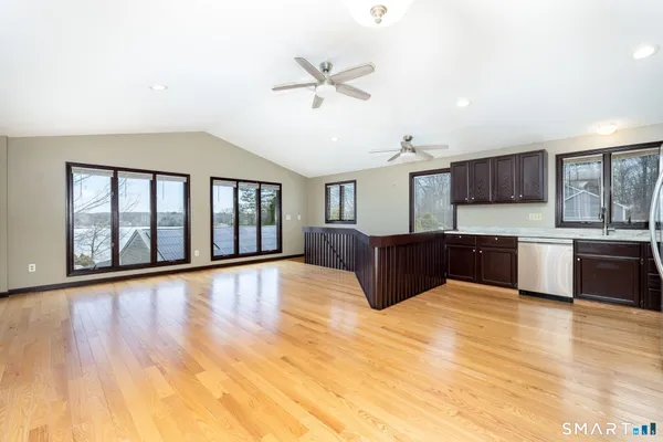 a large kitchen with stainless steel appliances wooden floors and view living room