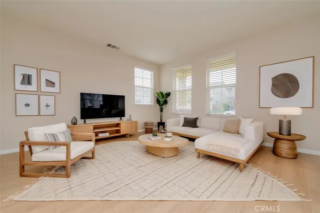 a living room with furniture a flat screen tv and a large window