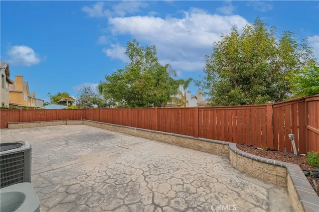 a view of backyard with wooden fence and large trees