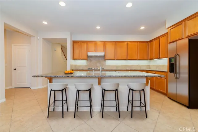 a kitchen with stainless steel appliances granite countertop a table and chairs