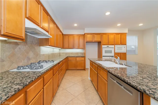 a kitchen with stainless steel appliances granite countertop a sink and a stove