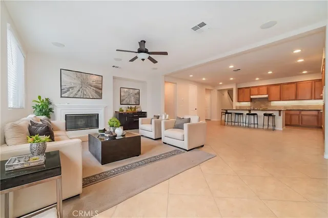 a living room with furniture a fireplace and a kitchen view