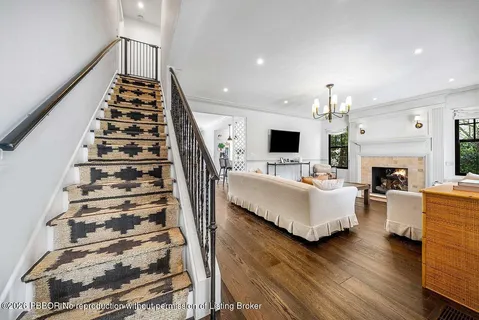 a living room with furniture a fireplace and a large window