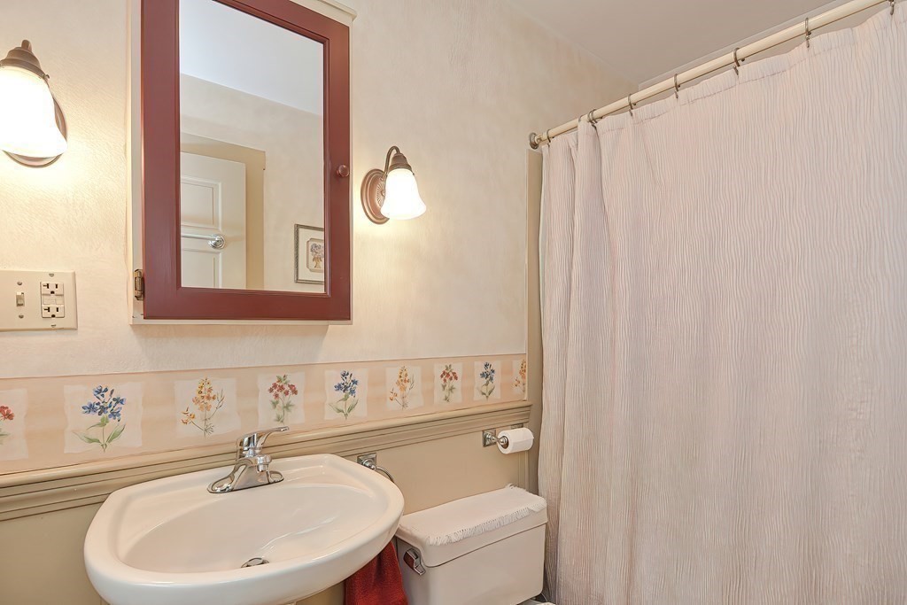 727 Main Street Woburn, MA 01801 - Photo 11 of 40 a bathroom with a sink a toilet and a mirror