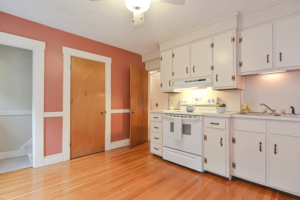 727 Main Street Woburn, MA 01801 - Photo 22 of 40 a kitchen with granite countertop white cabinets and white appliances