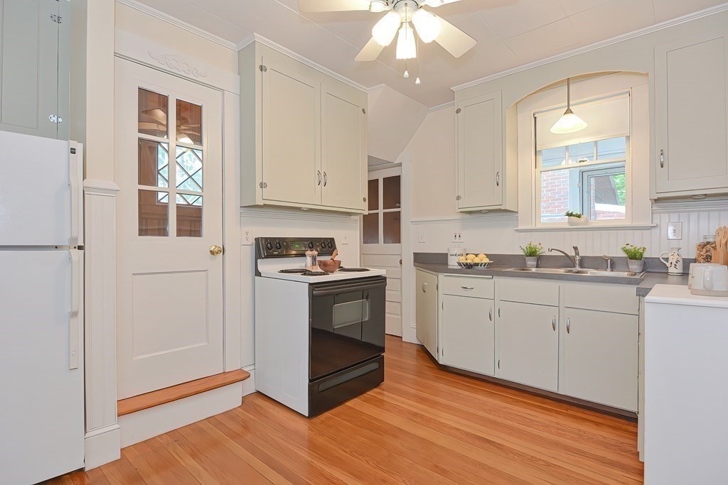 727 Main Street Woburn, MA 01801 - Photo 33 of 40 a kitchen with granite countertop white cabinets and white appliances