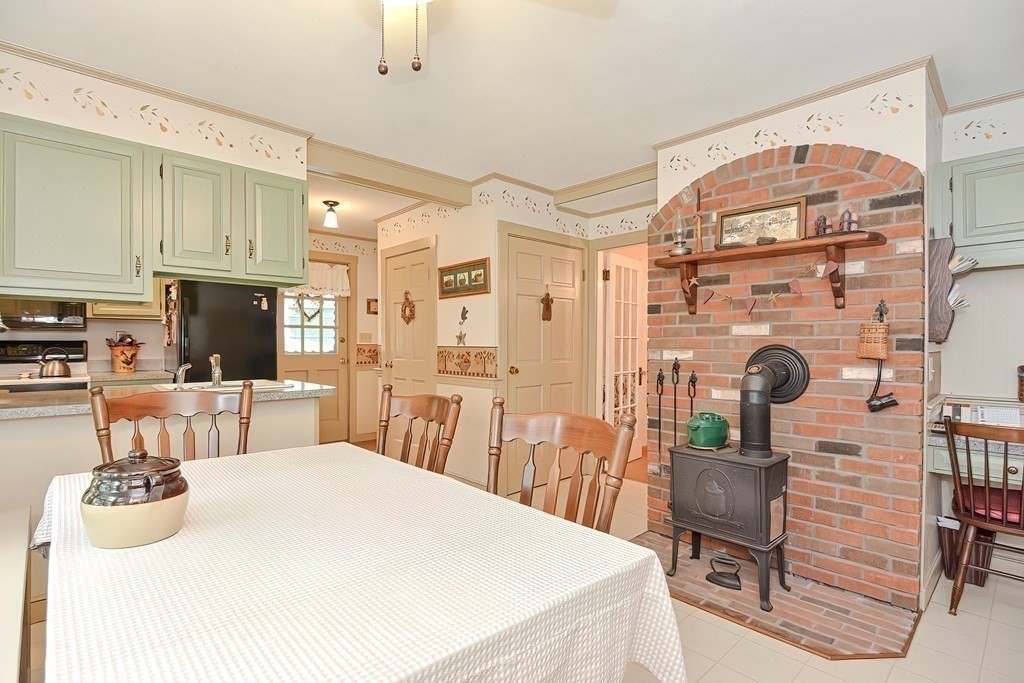 727 Main Street Woburn, MA 01801 - Photo 7 of 40 a kitchen with stainless steel appliances kitchen island granite countertop a table and chairs in it