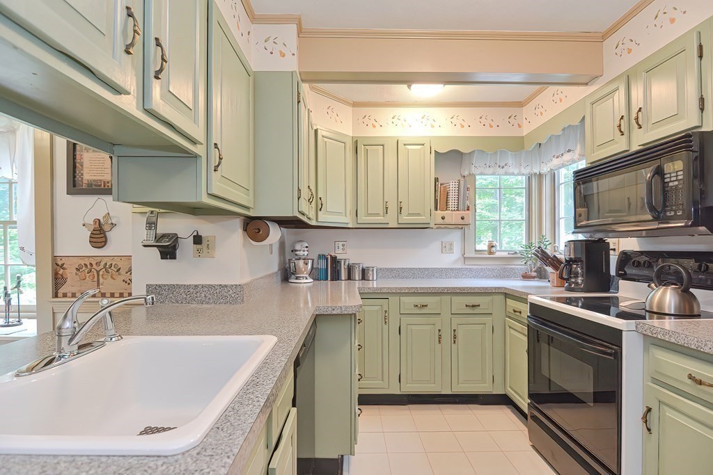 727 Main Street Woburn, MA 01801 - Photo 9 of 40 a kitchen with a sink stove top oven and cabinets
