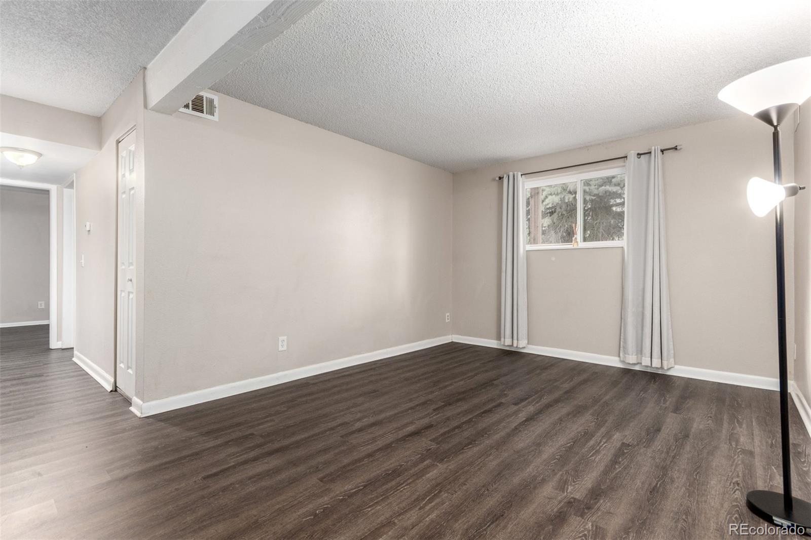 16359 West 10th Avenue, Unit O Golden, CO 80401 - Photo 7 of 25 a view of an empty room with wooden floor and a window