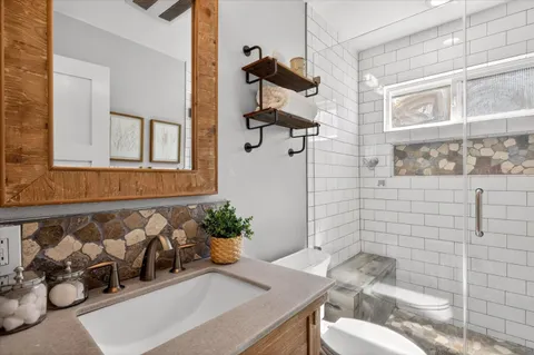 a bathroom with a sink toilet and shower