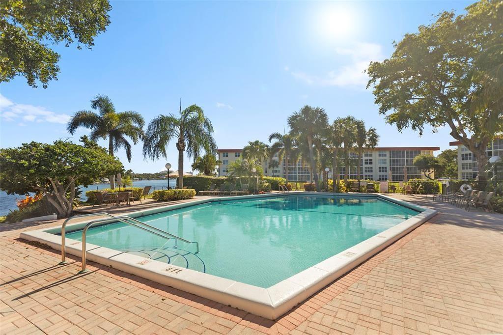 3100 Northeast 48th Court, Unit 413 Lighthouse Point, FL 33064 - Photo 23 of 32 a view of swimming pool with outdoor seating and yard