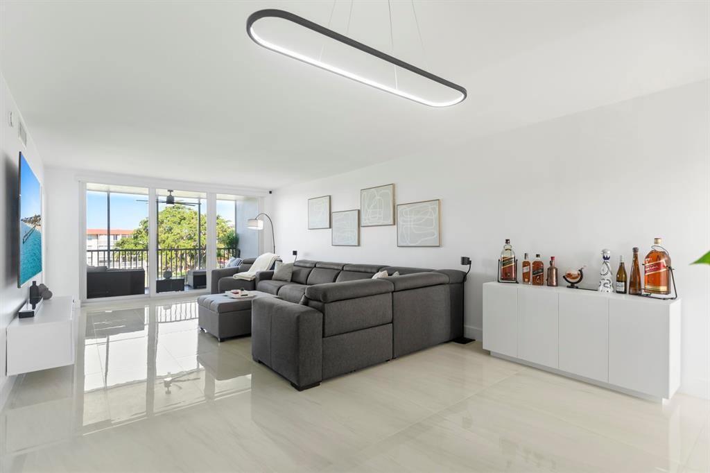 3100 Northeast 48th Court, Unit 413 Lighthouse Point, FL 33064 - Photo 5 of 32 a living room with furniture and a large window