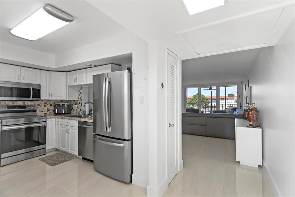 3100 Northeast 48th Court, Unit 413 Lighthouse Point, FL 33064 - Photo 6 of 32 a kitchen with stainless steel appliances a refrigerator sink and stove