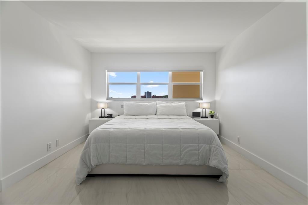 3100 Northeast 48th Court, Unit 413 Lighthouse Point, FL 33064 - Photo 10 of 32 a bedroom with a bed and a window