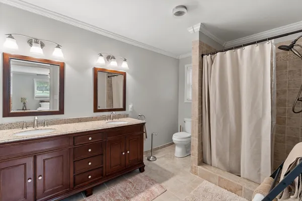 a bathroom with a double vanity sink toilet and a mirror
