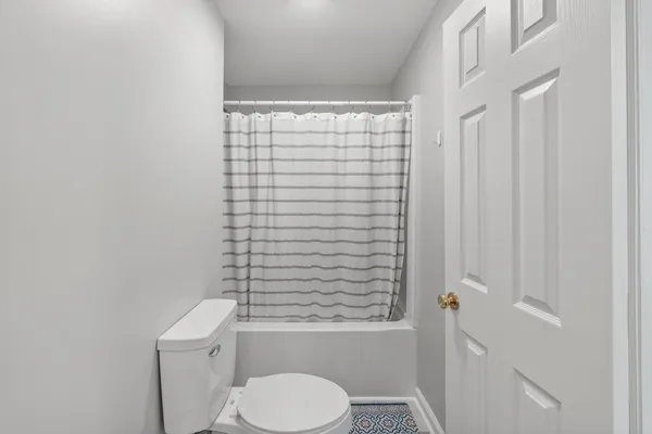 a bathroom with a toilet and a shower