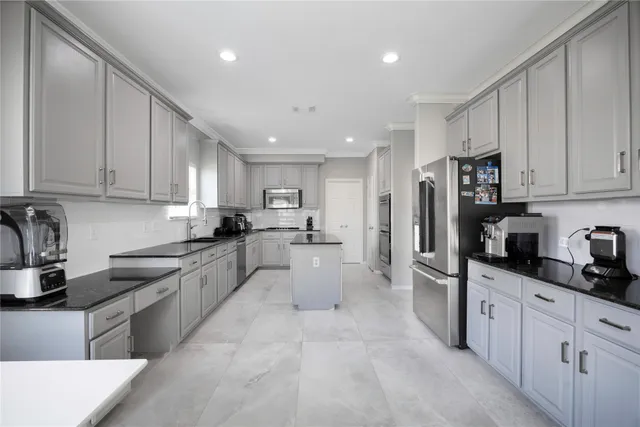 a large kitchen with stainless steel appliances lots of counter space sink refrigerator and cabinets