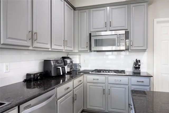 a kitchen with granite countertop white cabinets and white appliances