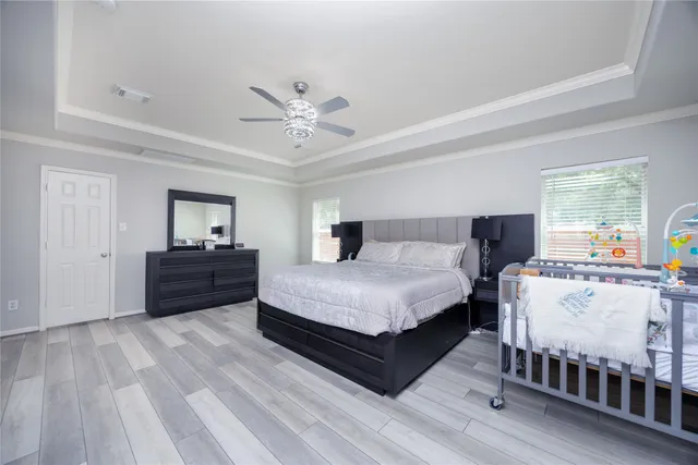 a spacious bedroom with a bed and wooden floor