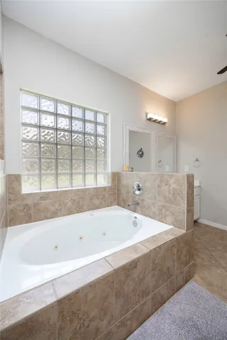 a bathroom with a tub sink and mirror