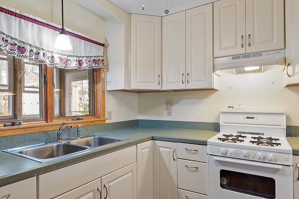 75 Conleys Grove Road Derry, NH 03038 - Photo 21 of 41 a kitchen with granite countertop a sink stove and cabinets
