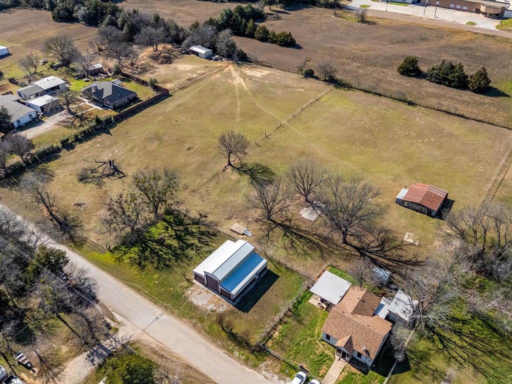 Tbd South Ewing Street Boyd, TX 76023 - Photo 15 of 24 Aerial view showcasing a property with a brown-roofed home, an additional building with a metal roof, and an outbuilding with a red roof
