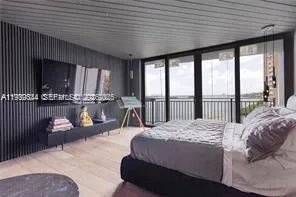 a bedroom with a bed couch and a large window