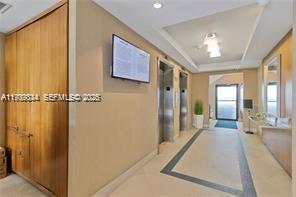 770 Northeast 69th Street, Unit 6E Miami, FL 33138 - Photo 10 of 13 a view of a hallway with wooden floor and chandelier