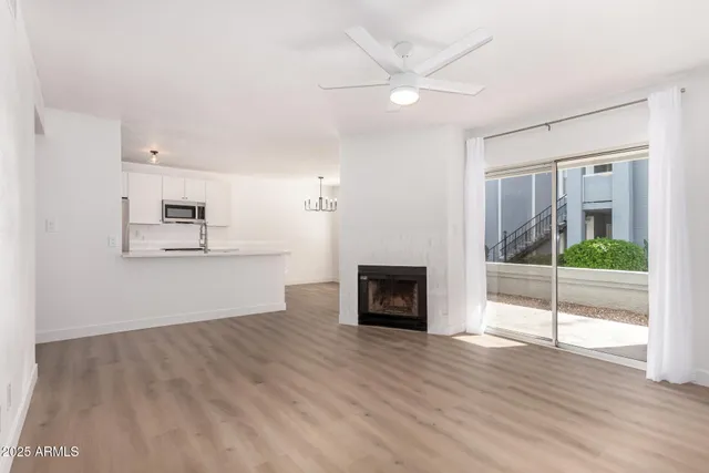 an empty room with wooden floor and a fireplace