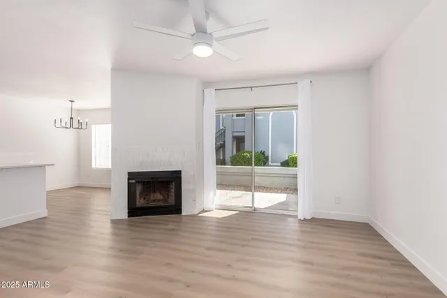 a view of a livingroom with wooden floor a fireplace and window