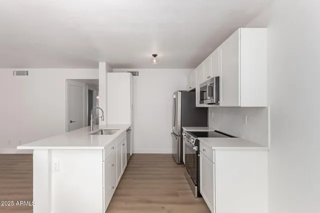 a kitchen with stainless steel appliances a refrigerator stove and sink